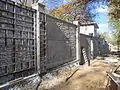 Concrete fence construction using aluminum forms to impart an ashlar stone impression in the finished product